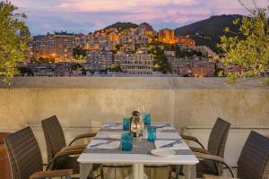 a table on a balcony with a view of a city at AC Hotel Genova by Marriott in Genoa