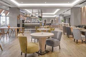 a restaurant with tables and chairs and a bar at AC Hotel Genova by Marriott in Genoa