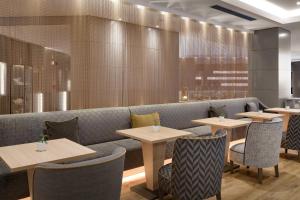 a restaurant with tables and chairs and a couch at AC Hotel Genova by Marriott in Genoa