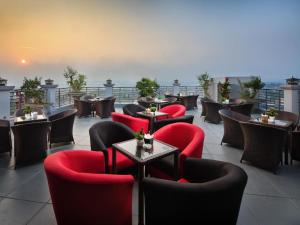 Un restaurante con sillas y mesas rojas en un tejado. en Royal Palace Hotel, en Tuyên Quang