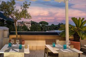 two tables on a balcony with a view of the city at AC Hotel Genova by Marriott in Genoa