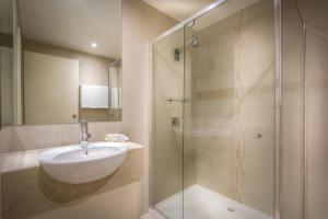a bathroom with a shower, sink, and tub at BEST WESTERN PLUS Travel Inn in Melbourne