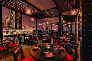 迪拜Renaissance Business Bay Hotel, Dubai的一间带桌椅的餐厅,享有城市天际线 更多61张照片