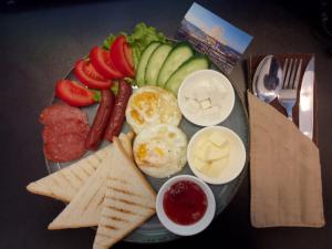 a plate of food with eggs sausage crackers and vegetables at Caspian Marine Hotel in Aktau +27 photos