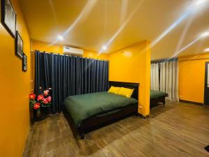a bedroom with two beds in a room with yellow walls at Old Quarter Autumn Hostel in Hanoi