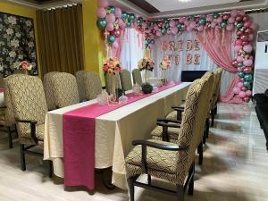 a long table with chairs and a pink table cloth at Fair crown Suites in Davao City