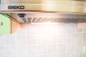 a stove top oven in a kitchen with white tiles at Apartment Ennio in Povlja