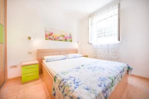 a small bedroom with a bed and a window at Apartment Ennio in Povlja