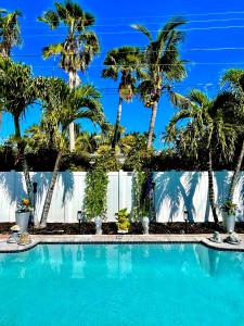 a swimming pool with palm trees in the background at Tropical Oasis Private Guest Suite min to Wilton Drive-Ft Lauderdale Beaches in Fort Lauderdale
