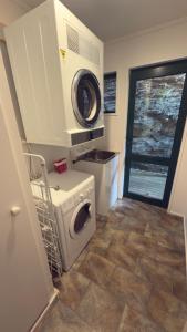 eine Waschküche mit Waschmaschine und Unterlegscheibe in der Unterkunft Lakeview Treehouse at Queenstown Hill in Queenstown