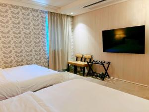首尔Hotel Lemong的一间有两张床和一台平板电视的酒店房间