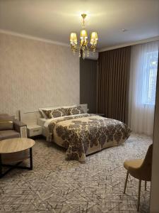 a bedroom with a bed and a chandelier at DEMIR Hotel in Taraz