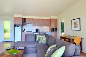 a living room with a couch and a kitchen at The Heavens Mountain Escape in Kangaroo Valley