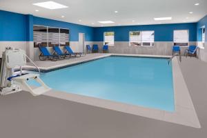 a swimming pool in a hospital room with blue chairs at Hampton Inn & Suites Hershey in Hershey