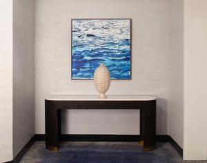 棕榈滩花园Embassy Suites by Hilton Palm Beach Gardens PGA Boulevard的坐在画前桌子上的花瓶