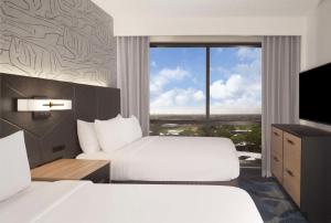 棕榈滩花园Embassy Suites by Hilton Palm Beach Gardens PGA Boulevard的有两张床和一扇大窗户的酒店房间 更多21张照片