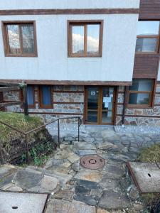 a house with a stone walkway in front of it at The New Inn in Bansko