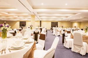 a banquet hall with white tables and chairs at Krystal Urban Aeropuerto Ciudad de Mexico in Mexico City