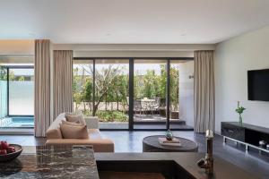 a living room with a couch and a television at Renaissance Bali Uluwatu Resort & Spa in Uluwatu