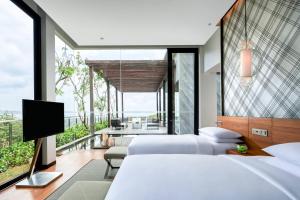 a bedroom with two beds and a flat screen tv at Renaissance Bali Uluwatu Resort & Spa in Uluwatu