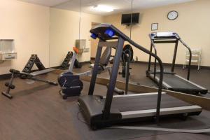 a gym with several tread machines and a clock at Comfort Inn & Suites Syracuse-Carrier Circle in East Syracuse