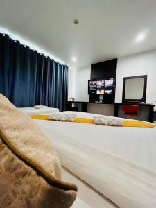 a hotel room with two beds with a tv on the wall at Bualinn Resort in Nong Khai +81 photos