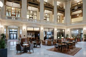 底特律Hotel David Whitney, Autograph Collection的酒店大堂里摆放着桌椅