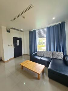 a living room with a blue couch and a coffee table at Bualinn Resort in Nong Khai