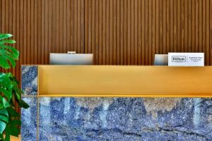 a wooden counter with two laptops on top of it at Tumbi Hotel Dubai The Palm,Tapestry Collection Hilton in Dubai