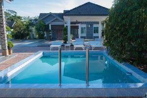 a swimming pool in front of a house at Anjung Teh Legacy in Jitra