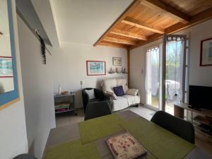 a living room with a couch and a table at Maison lumineuse au calme, pres mer in Le Château-dʼOléron