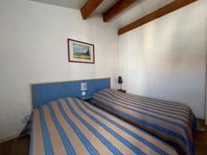 a bedroom with a blue and white striped bed at Maison lumineuse au calme, pres mer in Le Château-dʼOléron