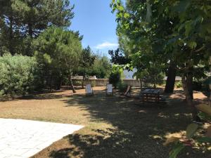 un groupe de tables de pique-nique dans un parc arboré dans l'établissement Maison à 8min de plage Giraudière, à Grand-Village-Plage