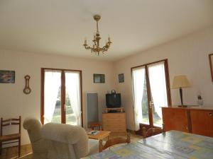 - un salon avec un lustre, une table et des chaises dans l'établissement Maison à 8min de plage Giraudière, à Grand-Village-Plage