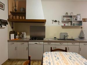 une petite cuisine avec un évier et une cuisinière dans l'établissement Maison à 8min de plage Giraudière, à Grand-Village-Plage 2 autres photos