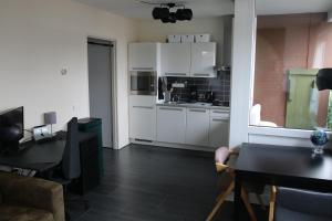 a kitchen with white cabinets and a table in a room at Business Apartment Solar Eindhoven in Eindhoven