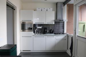 a white kitchen with white cabinets and appliances at Business Apartment Solar Eindhoven in Eindhoven
