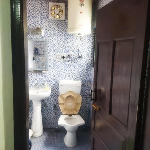 a bathroom with a toilet and a sink at Rose Bowl Guest House Homestay in Bāgh Chandpura