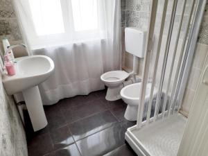 a bathroom with a sink and a toilet and a window at bbsulmare-com Sole Apartment in Porto Empedocle