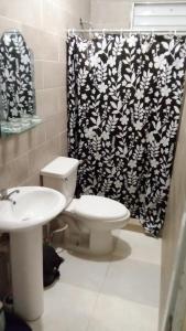 a bathroom with a toilet and a shower curtain at Chez Guela in Mandinga