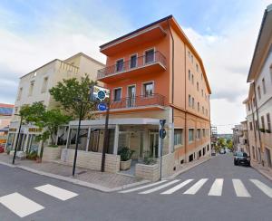 an orange building on the corner of a street at HOTEL HOUSE GARGANO in San Giovanni Rotondo