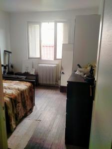 Zimmer mit einem Bett, einer Kommode und einem Kühlschrank in der Unterkunft Court séjour à Paris 2mn de métro in Villejuif