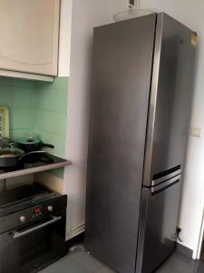 einen Kühlschrank aus Edelstahl in der Küche in der Unterkunft Court séjour à Paris 2mn de métro in Villejuif