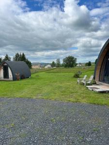 a group of chairs in a field next to a building at Chalet cosy en Aubrac in Nasbinals
