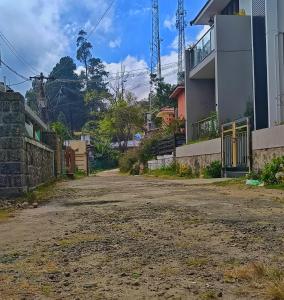 una calle vacía delante de una casa en Smiley Homestay Family-Friendly 3BR, en Kodaikanal 29 fotos más