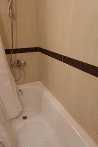 a bathroom with a bath tub with a shower at GO GO Holiday in Borovets