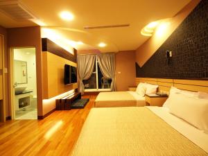 a hotel room with two beds and a bathroom at Ibizakenting Hotel II in Kenting