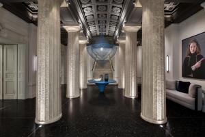 a hallway with columns and a staircase in a building at Dorothea Hotel, Budapest, Autograph Collection in Budapest