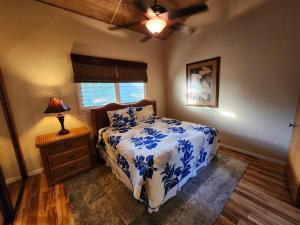 a bedroom with a blue and white bed and a lamp at Makahuena at Poipu in Koloa +21 photos