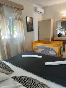 a bedroom with a bed with a crib and a dresser at DERES Apartments in Hanioti